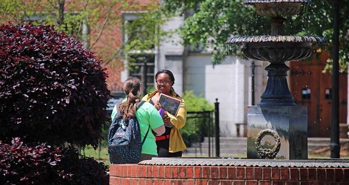 students talking at fountain